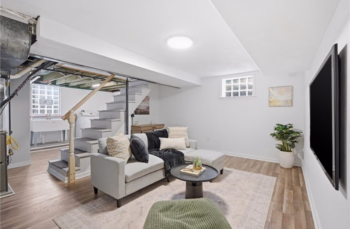 Finished basement living area, second angle, with seating and TV