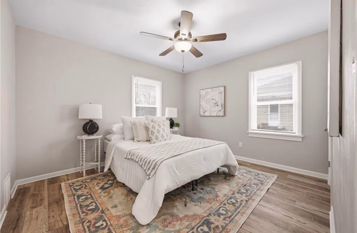 Finished bedroom, staged with a bed, rug, and decor