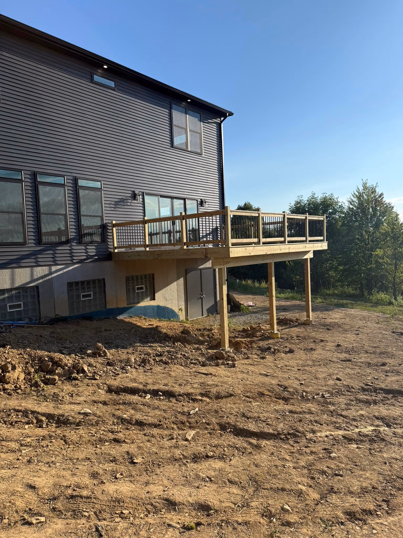 Raised wood deck under construction behind a home