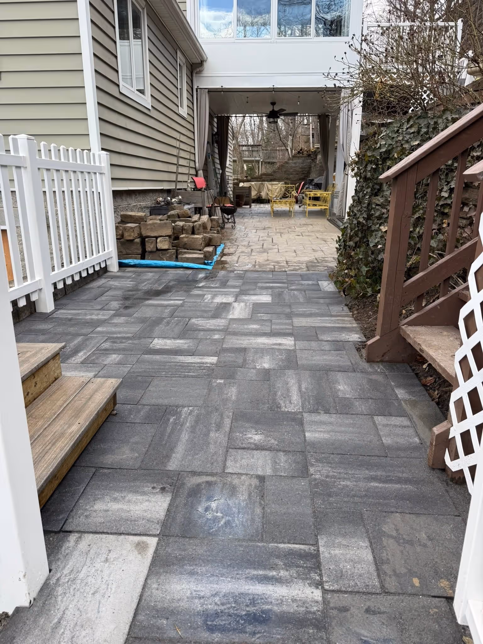 Gray paver walkway leading into a patio area