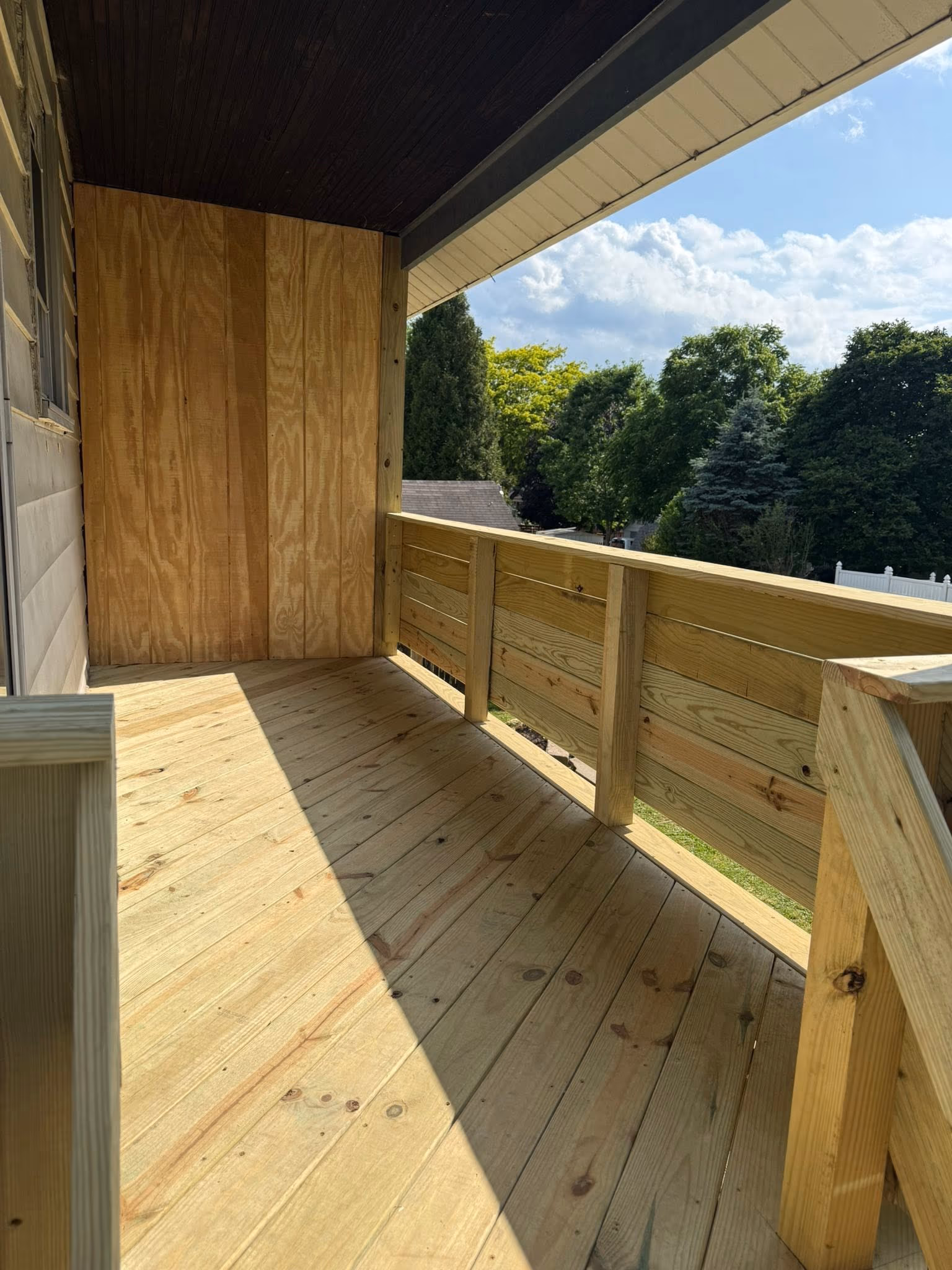 Covered wood porch floor, railing, and finished ceiling