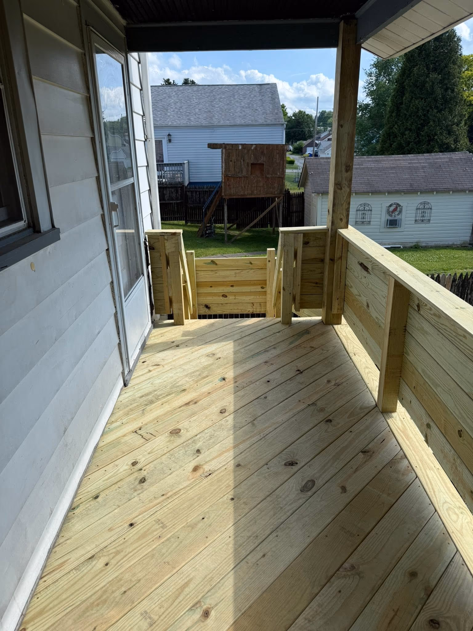 Wood porch floor, railing, and gate viewed toward the stairs