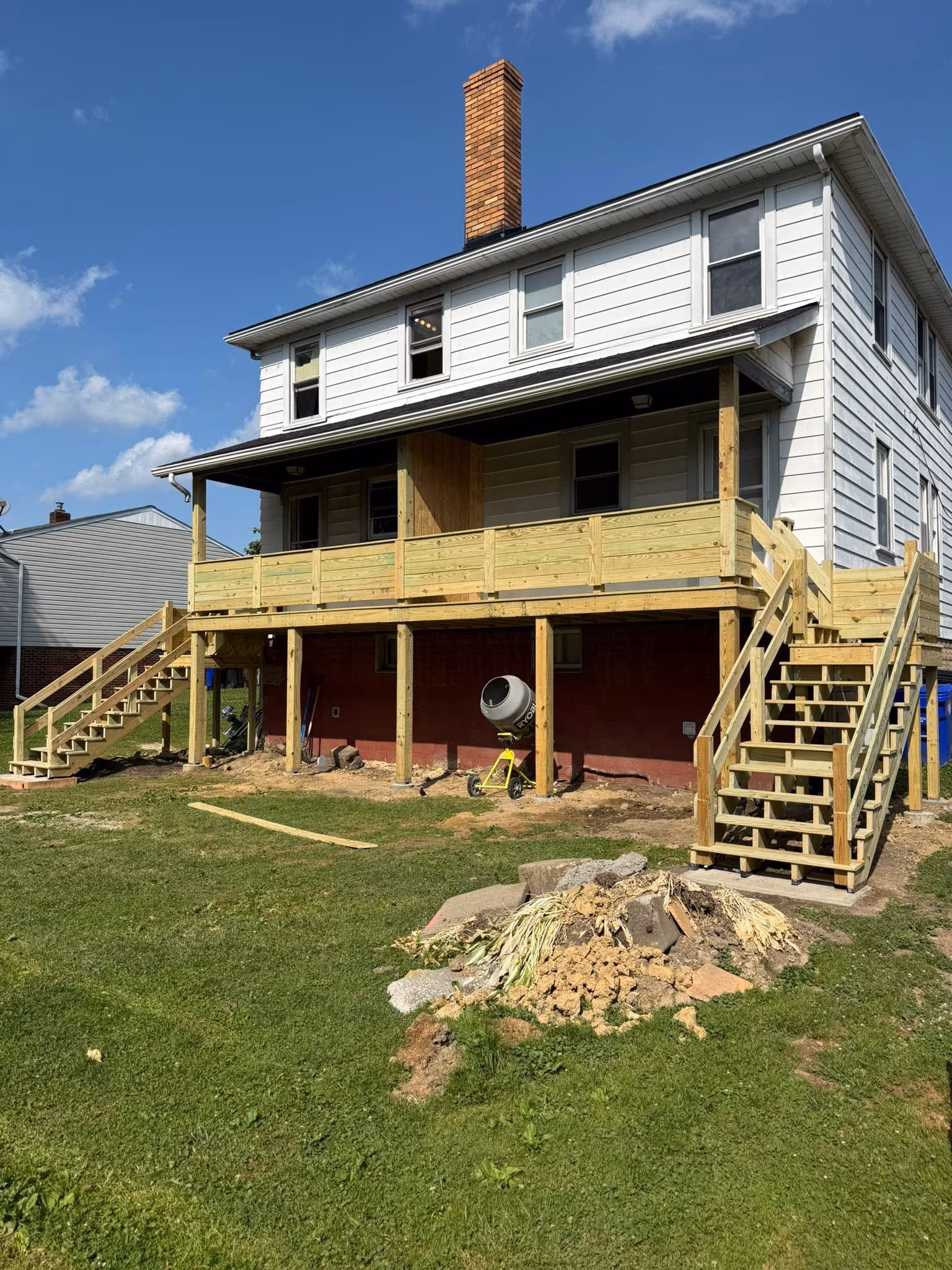 Angled exterior view of the new rear porch, deck, and stairs